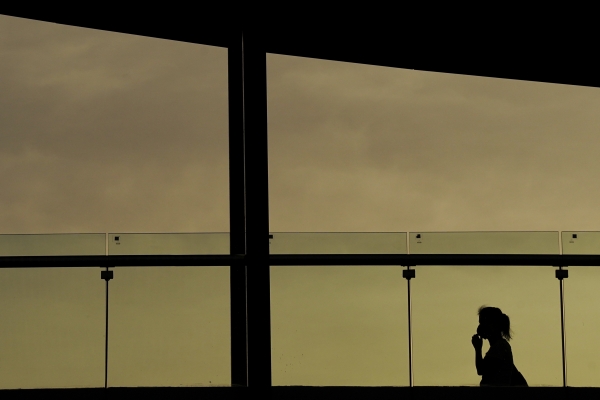 Silhouettes of woman walking on a bridge. - The Shot